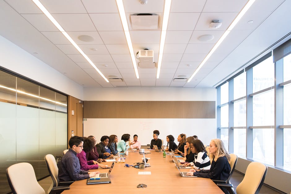 A diverse group of employees collaborating in a meeting room discussing ideas.